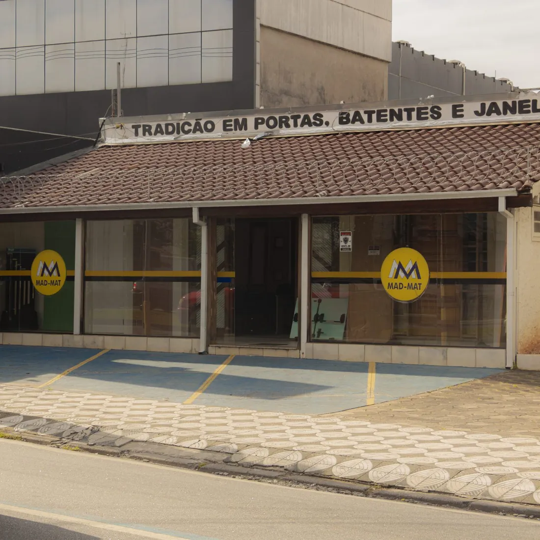 Fachada da Mad Mat na Av. General Carneiro, com o letreiro Tradição em portas, batentes e janelas